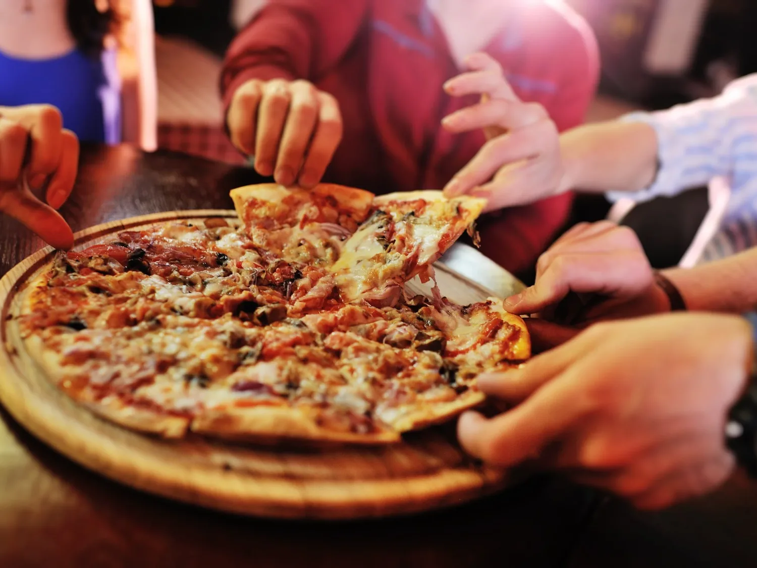 Friends sharing a fresh pizza at the table